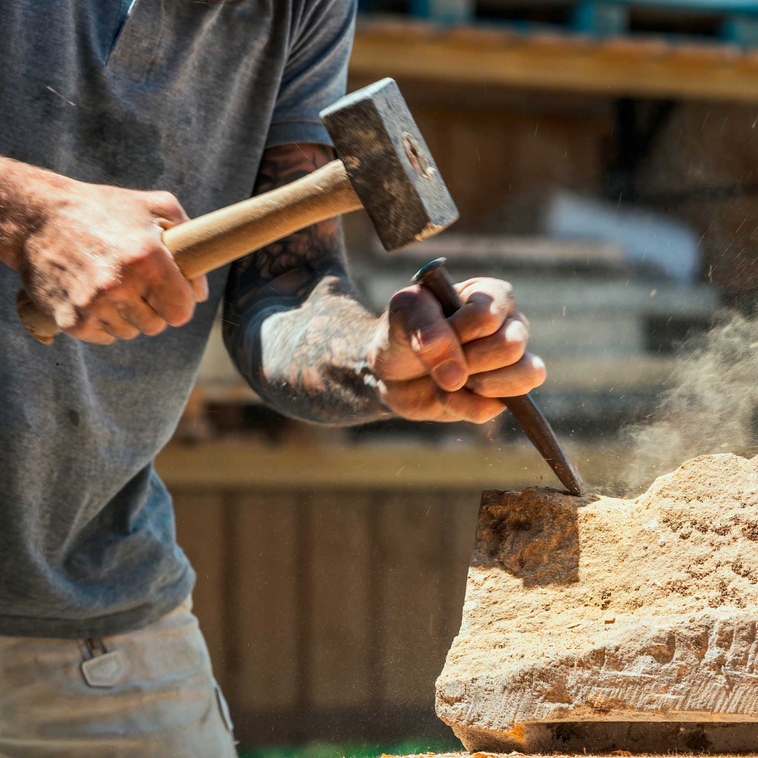 Tradesman chiseling stone block
